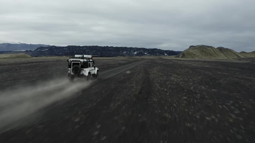 White jeep driving on dirt road in the desert