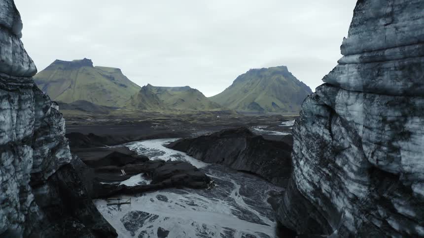 Aerial of a mountain range with stream during a cloudy day