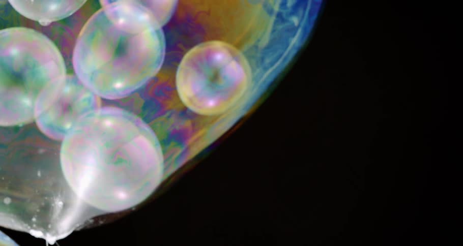 Bubbles with prisms move across black background