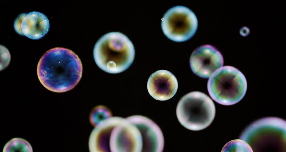Colorful bubbles falling against a black background