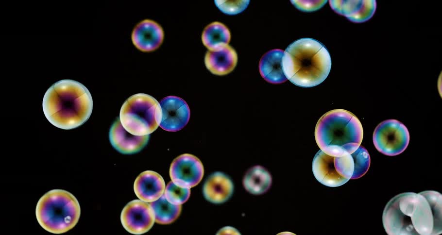 Colorful bubbles in slow motion on a black background