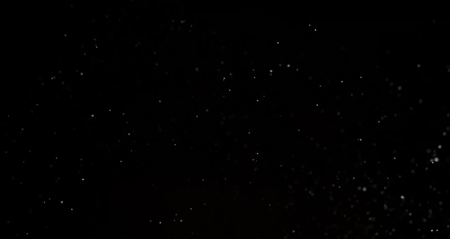 A homogeneous liquid with texture explodes and turns into several particles on a black background