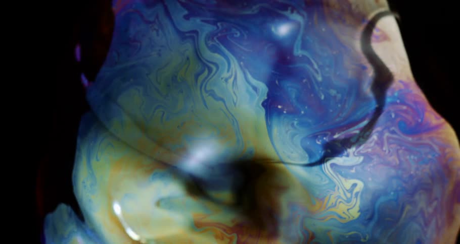 Microscopic view of an abstract soap bubble bursting in slow motion