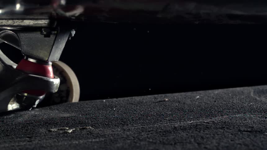 Extreme closeup of skateboard wheels moving in slow motion