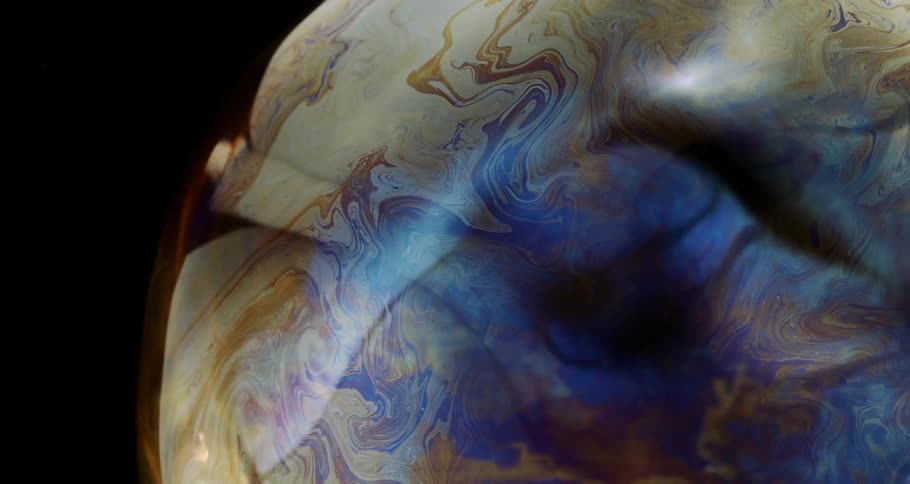 A colorful and homogeneous liquid moving on a black background