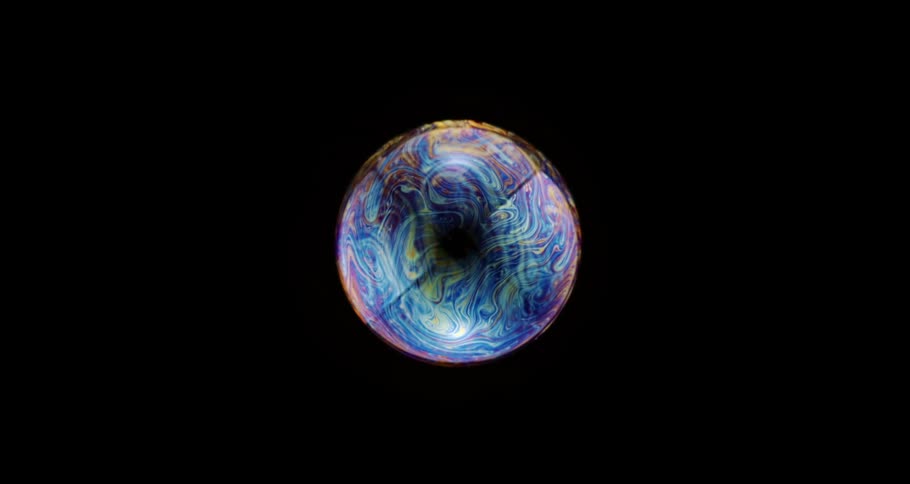 Dense colorful bubble in extreme closeup against a black background