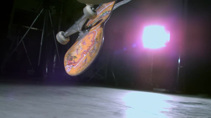 Closeup of a persons feet performing a skateboard trick in slow motion