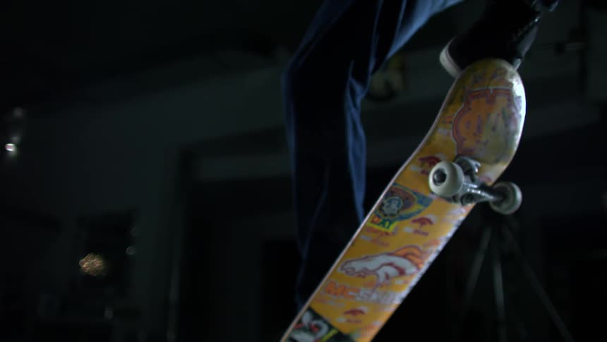 A person is doing a jump on a skateboard in a warehouse