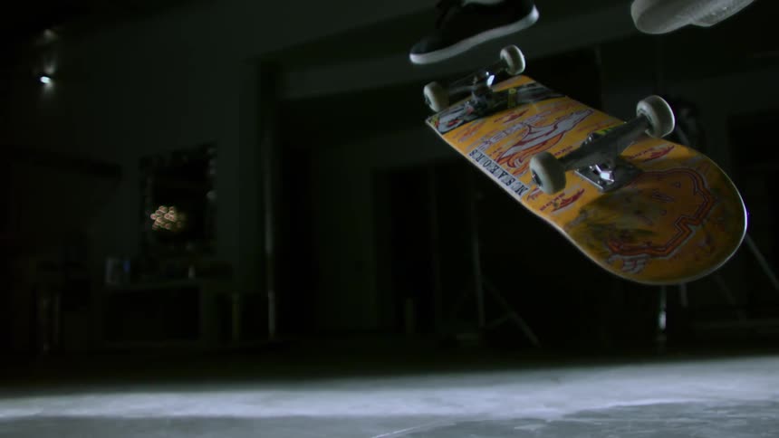 A person doing a skateboard flip trick in a photo studio
