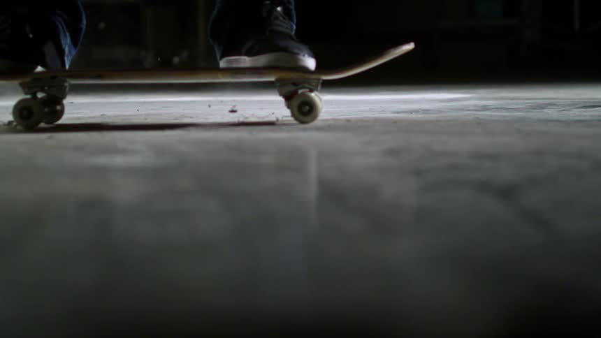 A person is skateboarding in the dark