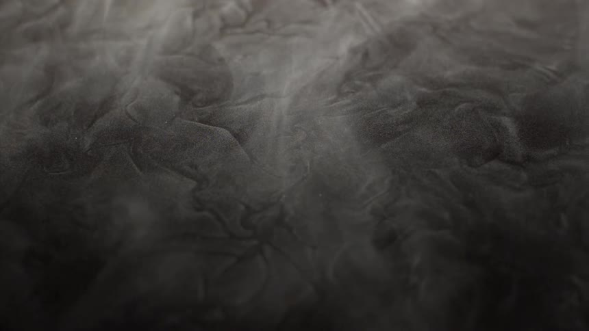 White smoke moves over a textured surface