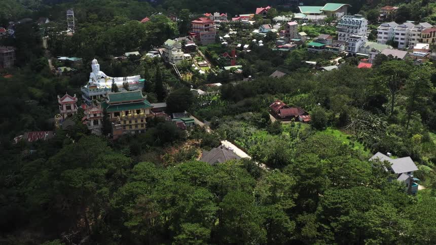 Aerial panorama of an urban city nestled among mountains with vegetation