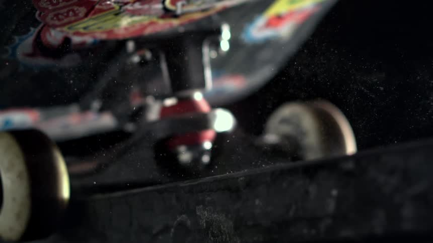 Extreme closeup of a skateboard maneuvering on an edge in slow motion