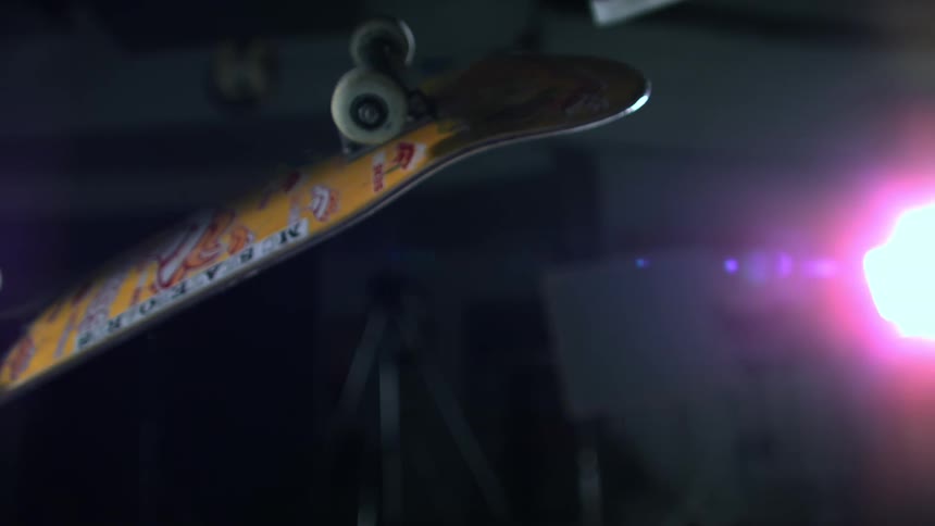 A person doing a trick with a skateboard making it spin in the air