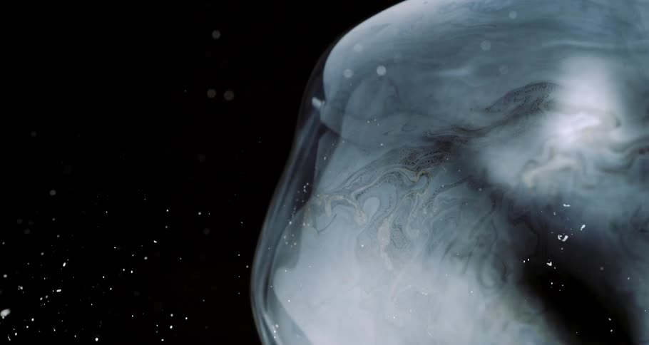Close view of large bubbles floating and bursting in slow motion in a studio environment