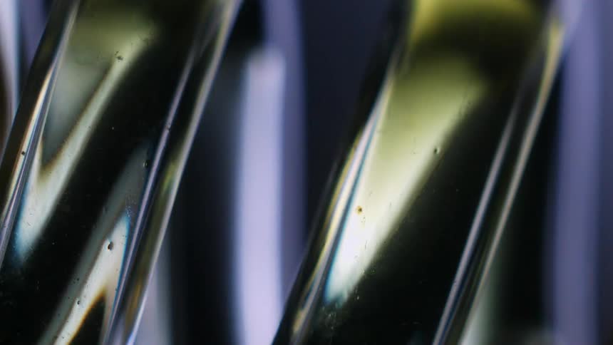 Golden liquid flowing through a spiral glass pipeline