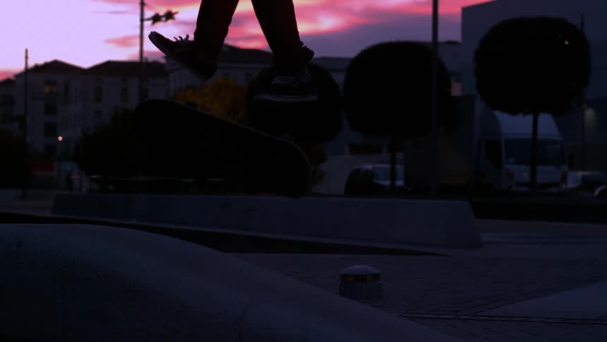 Person jumping on a skateboard trick in a purple late afternoon sky
