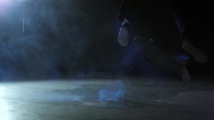 Man on a skateboard performing a trick in an indoor environment in slow motion