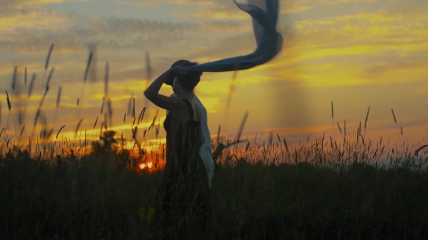 Two people walk through a field at dawn