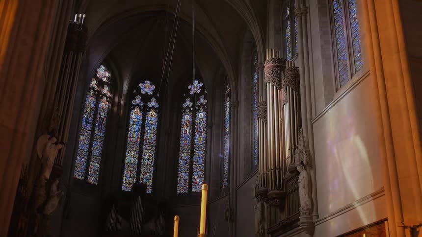 Stained glass windows cover a church wall