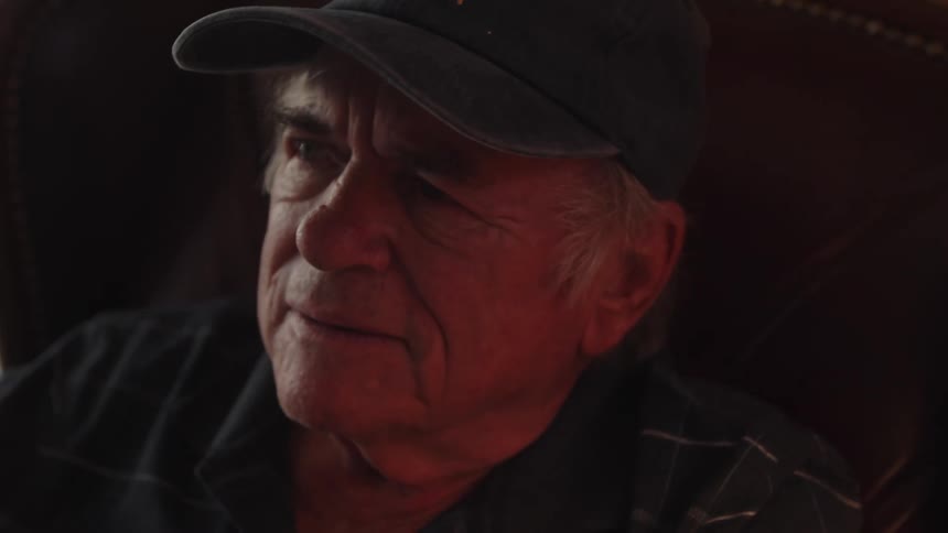 Portrait of an elderly person wearing a cap looking upwards