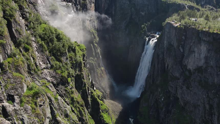 Aerial of a tall waterfall plunging over a cliff in a wilderness area