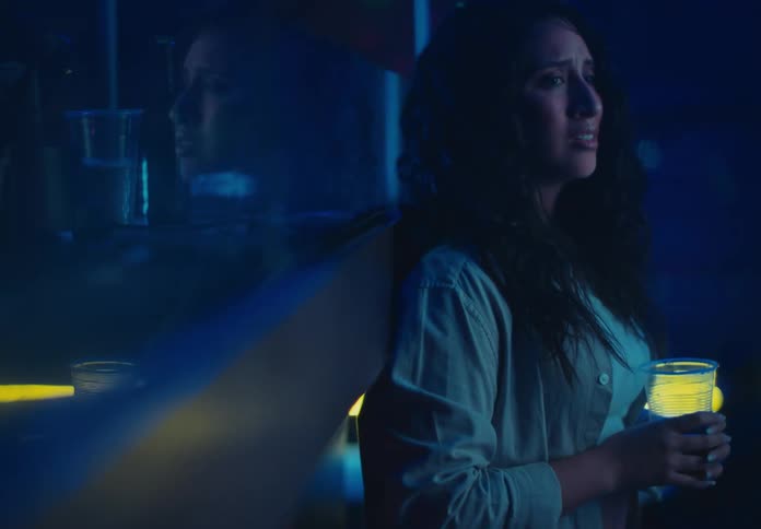 A woman with a glass in her hand talking to someone with distressed expressions