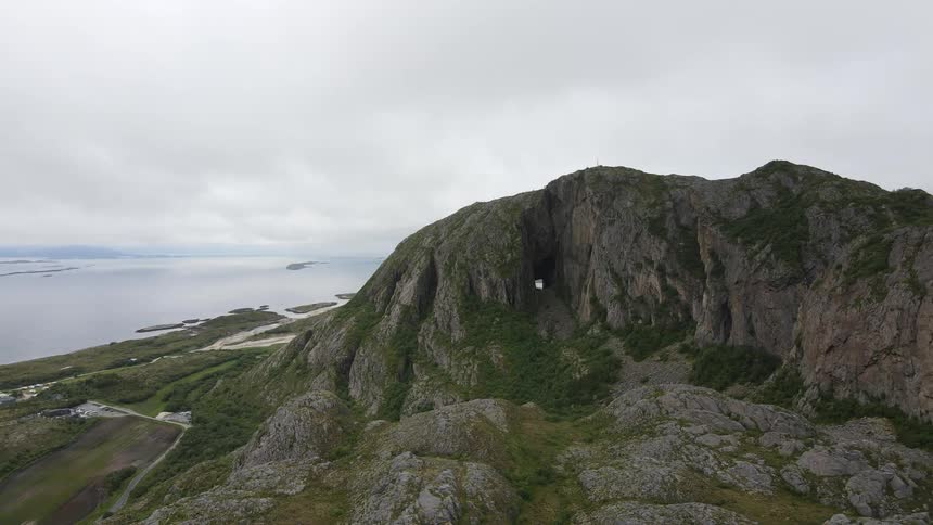 Aerial of rocky mountains with a beach coast in the background