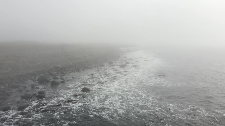 View of the sea with waves crashing on the shore with rocks