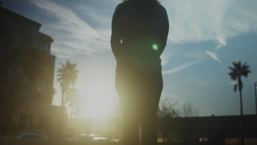 A woman brings her hands together while watching the sunrise