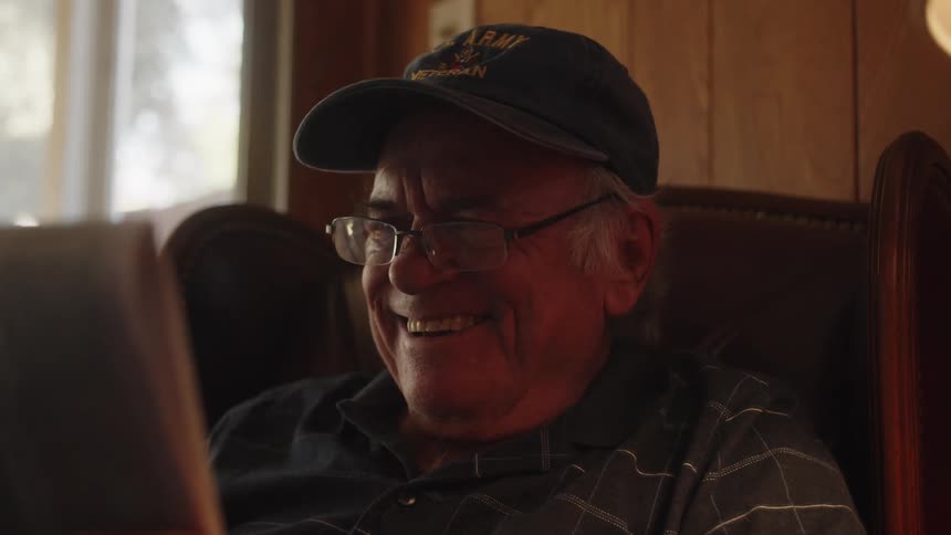 Closeup on the face of an elderly person sitting in an armchair smiling