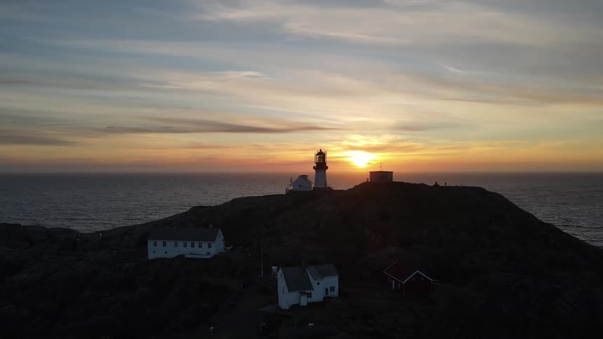 A light house is on the hill of the shore