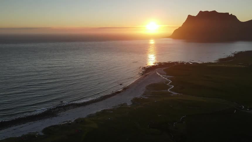 Aerial panorama of a seascape and coastline with the sunrise on the horizon