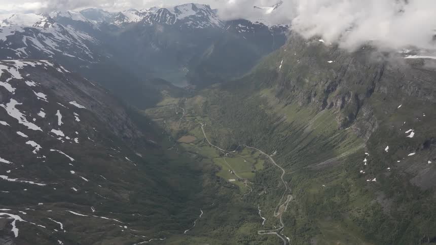 Aerial panorama of mountains and plateaus covered in snow on a day