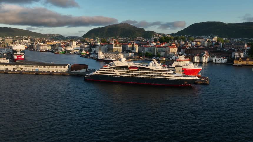 Aerial view of a large cruise ship docked in the harbor of a city