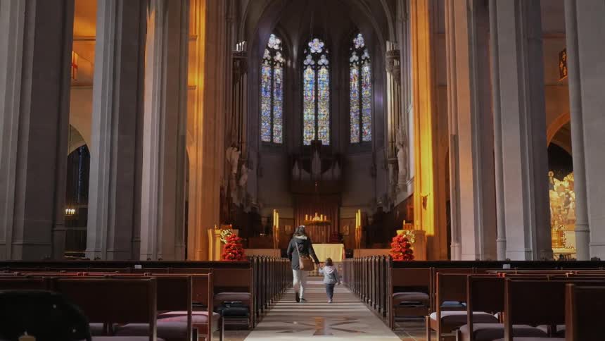 A woman guides a child to the front of a church