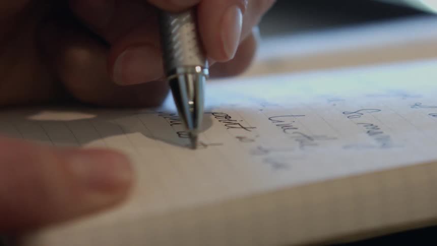 A person is writing in a notebook