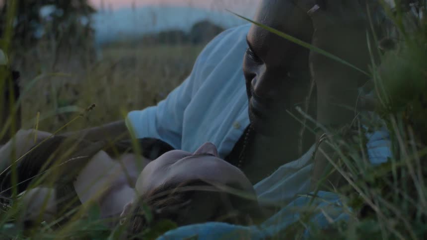A man and woman lying in the grass together