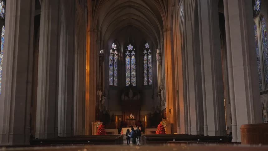 People are walking down the aisles of a church