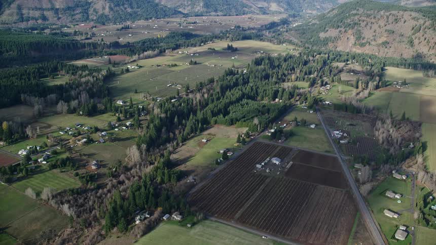 Aerial of a small rural town with plantations during the day