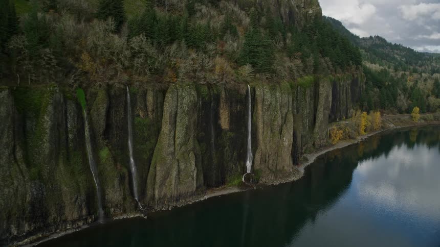 Aerial of the mountain with waterfall falling into the large lake during the day
