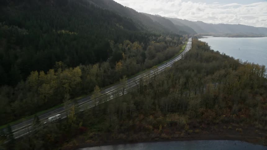 Aerial panorama of a highway in the middle of a lake and mountains
