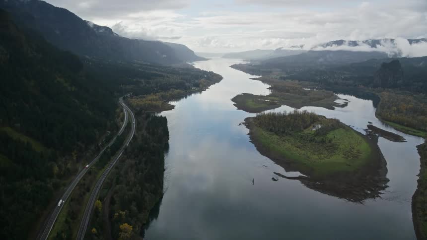 Aerial of a lake with islets in a landscape with forest and mountains
