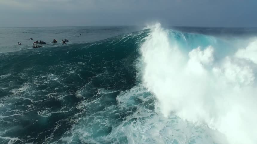 A surfer falls off their board and into a wave