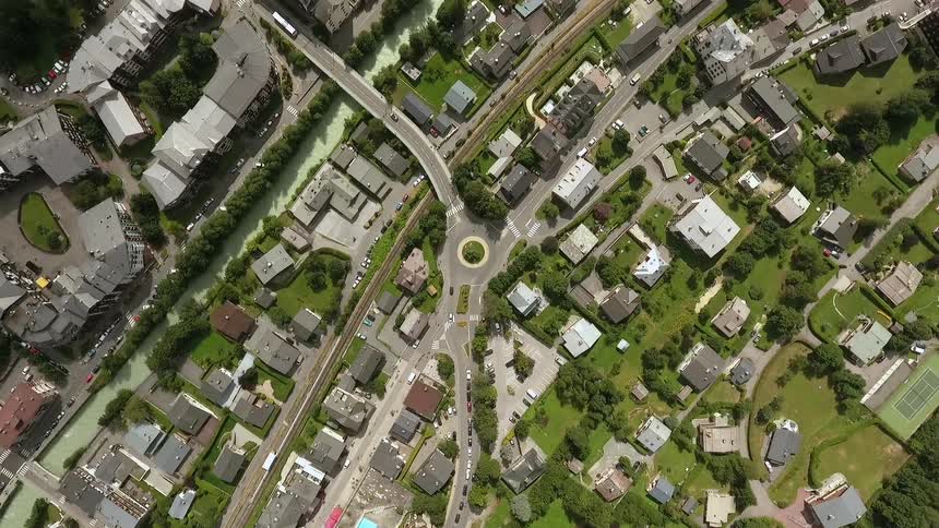 Vehicles travel on roads through the town below