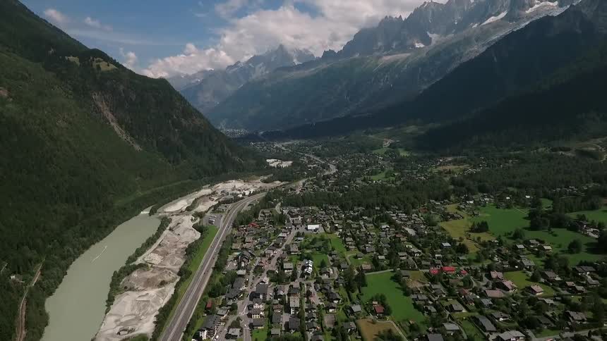 A large green mountain is on the side of this town