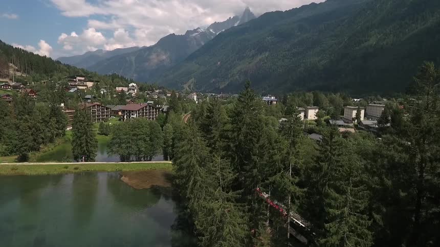 The train is passing by a lake near a town