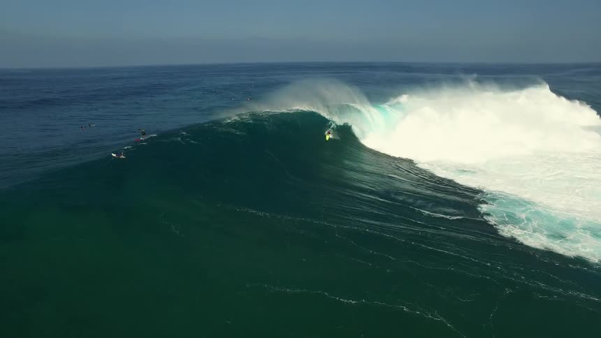 A person is riding a large wave in the ocean