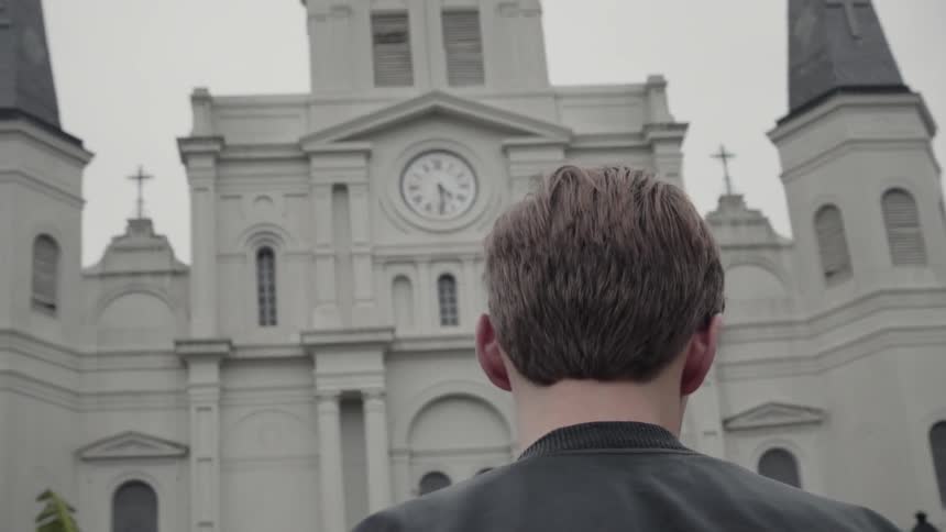 A person walks towards a church with a clock tower