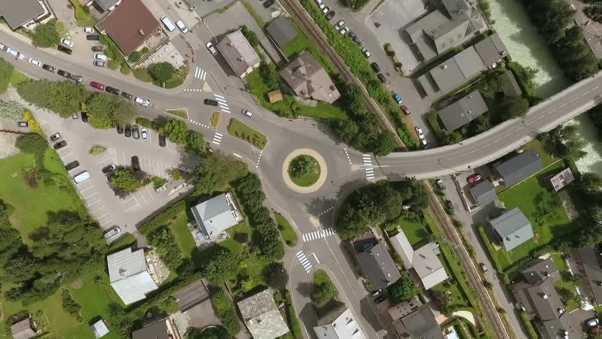 Cars drive on a loop through a neighborhood